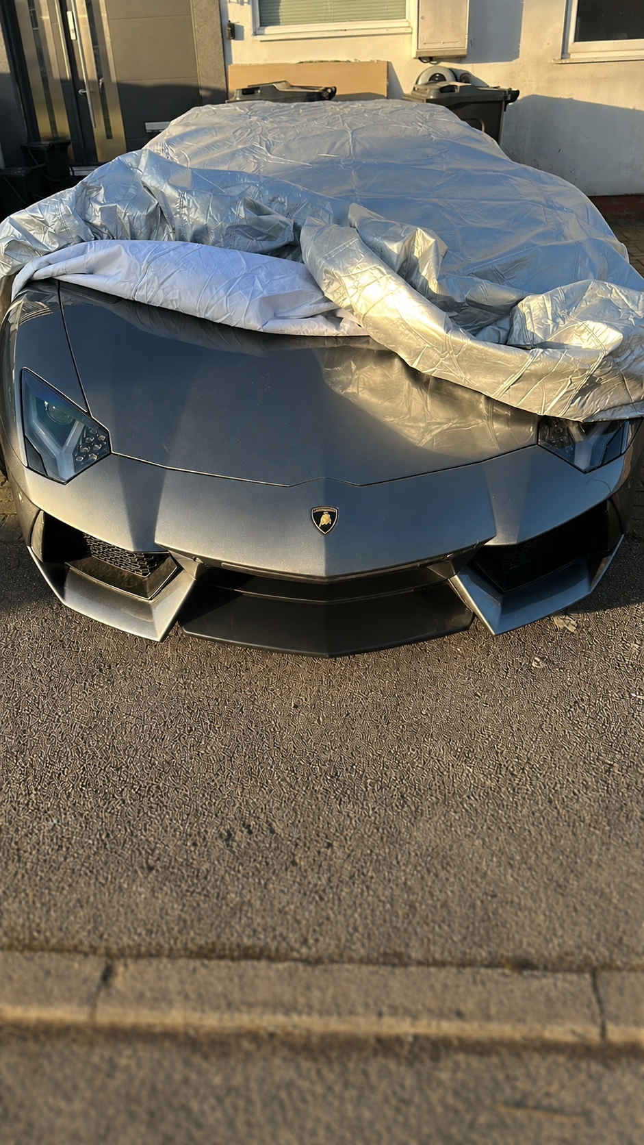 Lamborghini Aventador being uncovered ahead of a mobile body repair