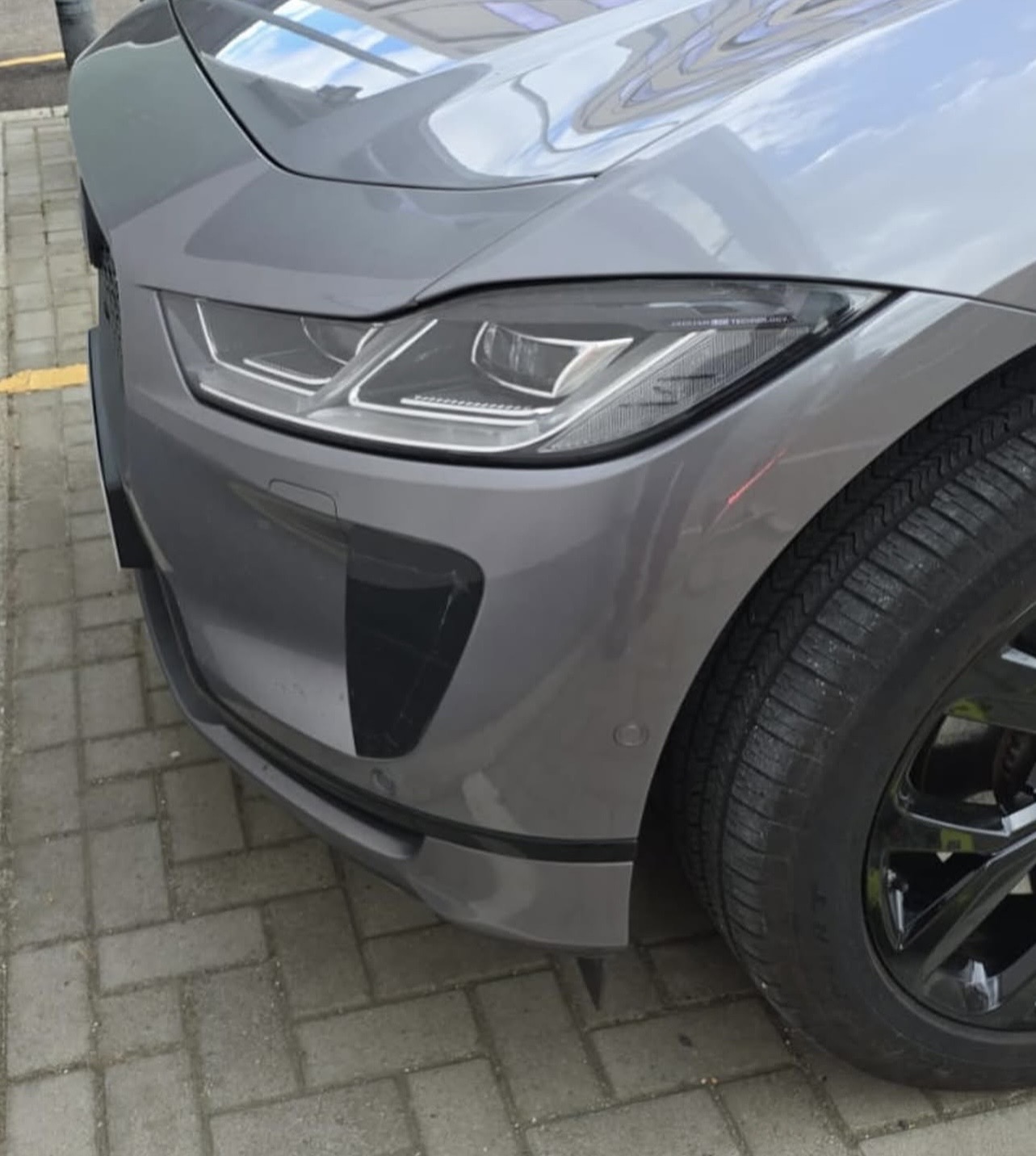 Restored grey Jaguar front wing and bumper after mobile body repair